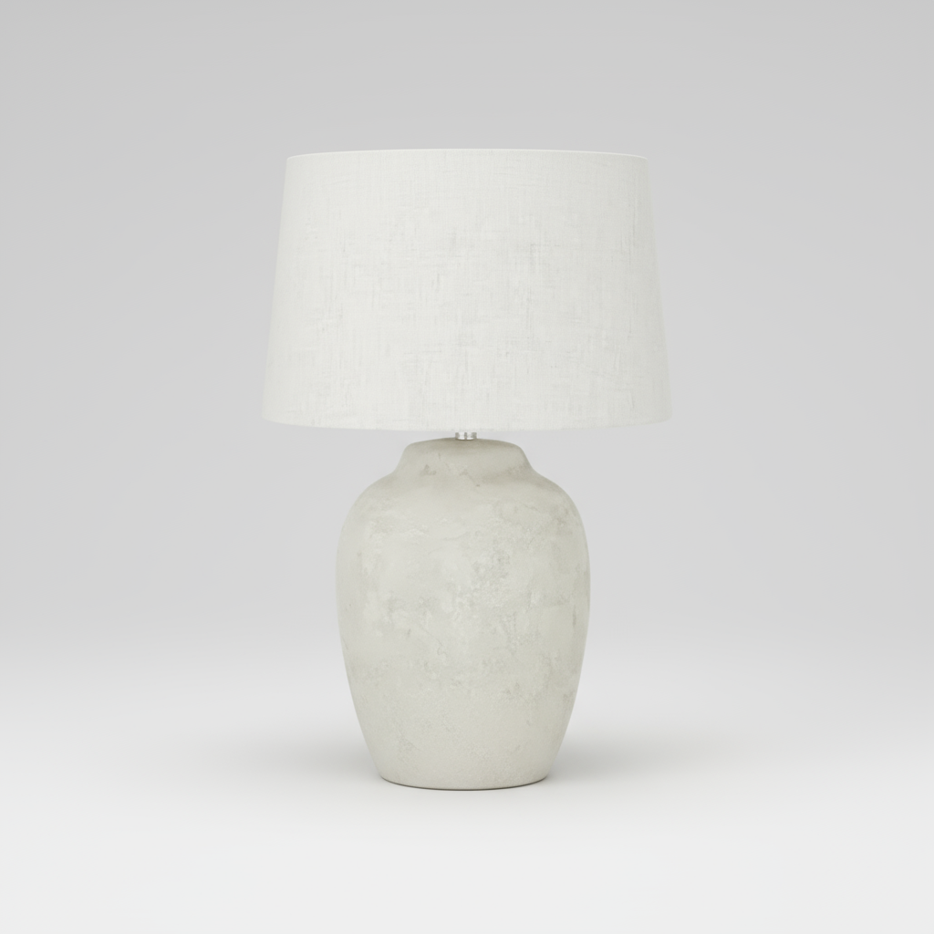 Table lamp with textured white base and light gray shade on a white background