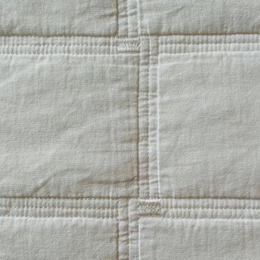 Close-up of a textured white fabric with quilted pattern