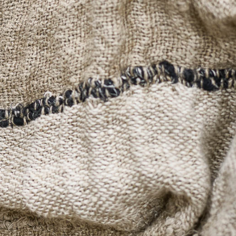 Close-up of beige fabric with black stitching detail