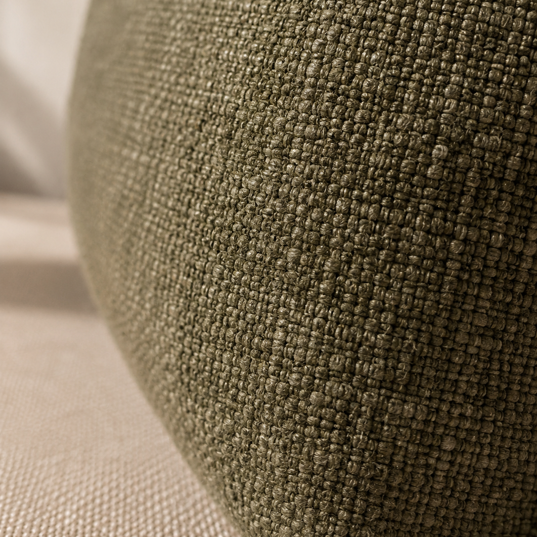 Close-up of a textured fabric cushion in an olive green color, showing the detailed woven material and soft curved shape.